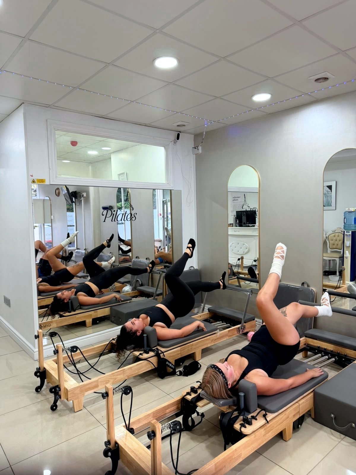 Clients on the Reformers working through a supported leg sequence