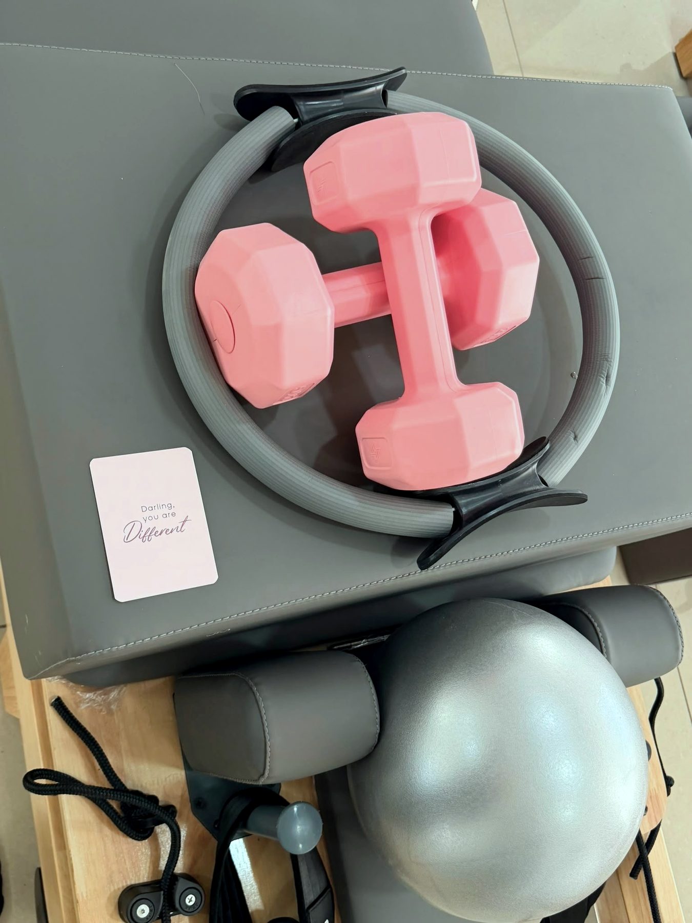 A Pilates ring, hand weights and a soft ball set out on a Reformer before class